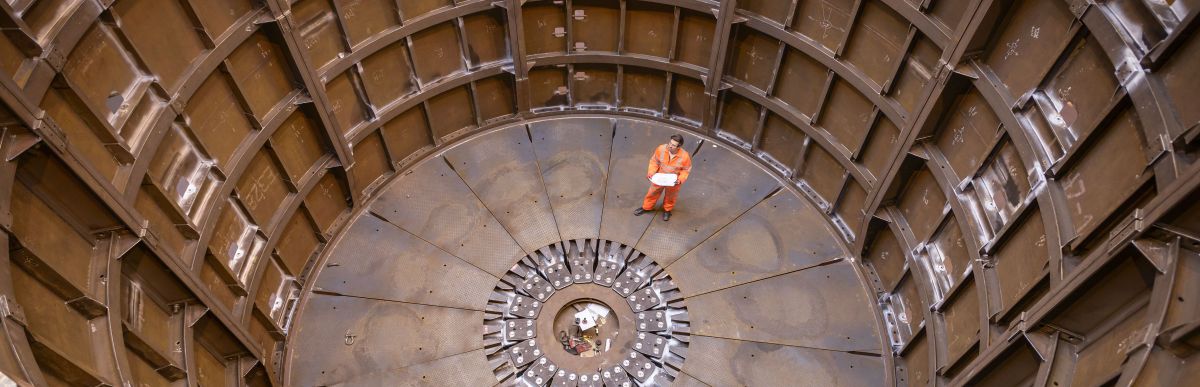 Engineer inspecting marine fabrication used for cable laying, high angle view
