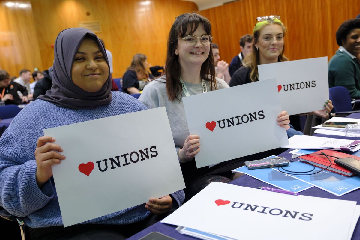Young workers hold HeartUnions signs