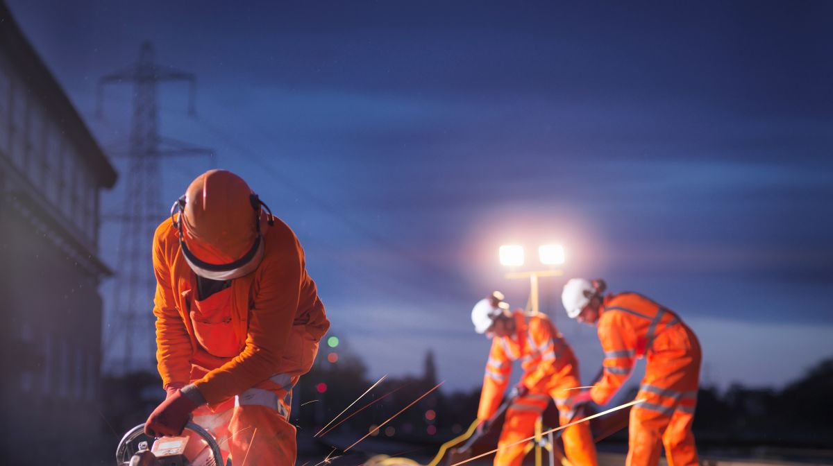 three railway workers at night