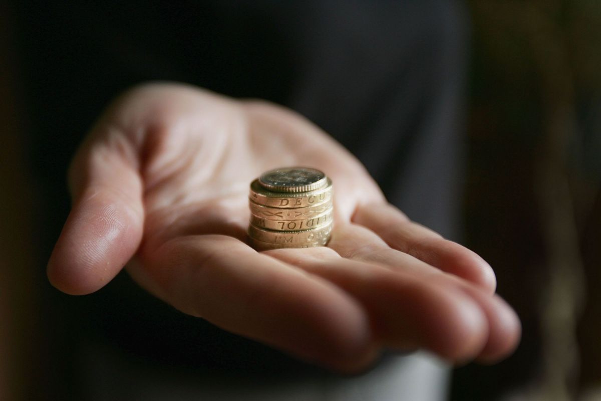 A hand holding some coins