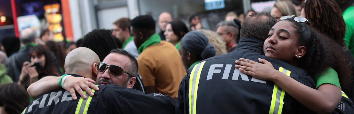 LONDON, ENGLAND - JUNE 14: People stop to hug firefighters during a silent march to St Marks Park (Kensington Memorial Park) 