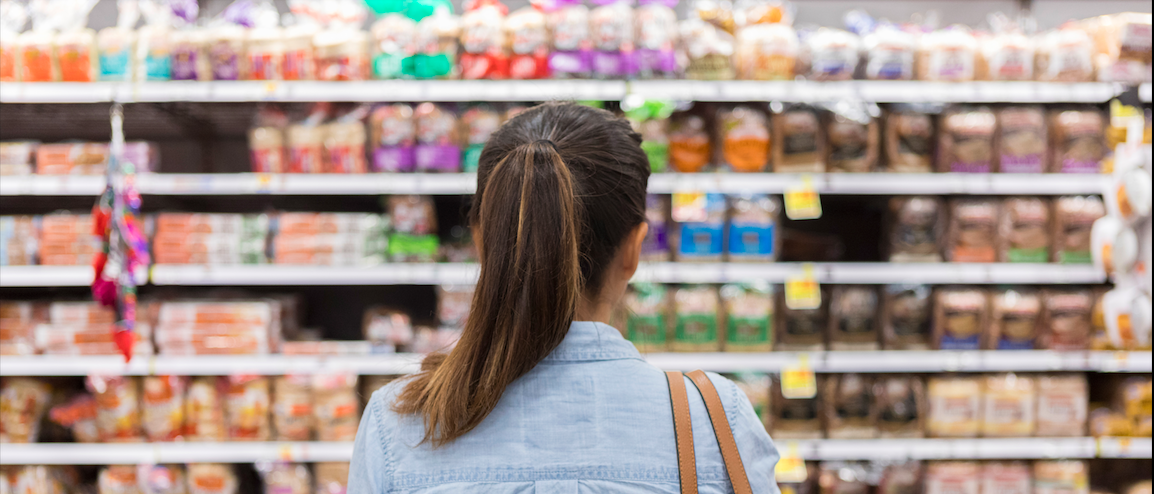 An unrecognisable woman looks at a supermarket shelf