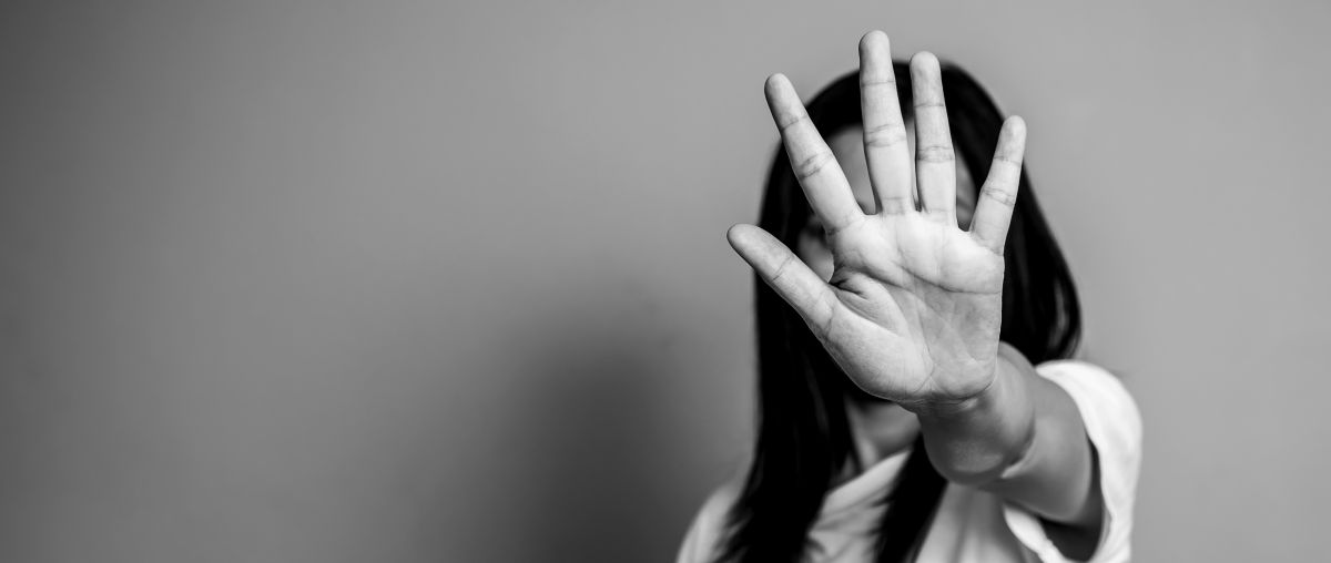 A black and white photo of a woman with her hand covering her face