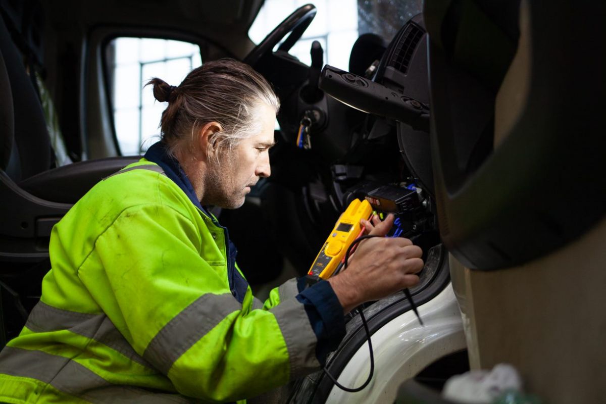 A worker inspects a vehicle. 