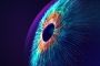Digital generated image of multicolored particles forming eye shape against black background.