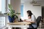 Woman working from a home office desk with her son