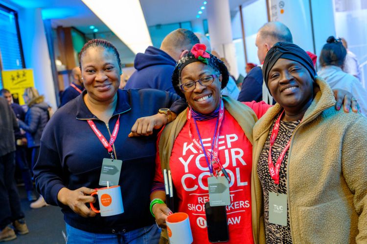 Three Black women standing together smiling