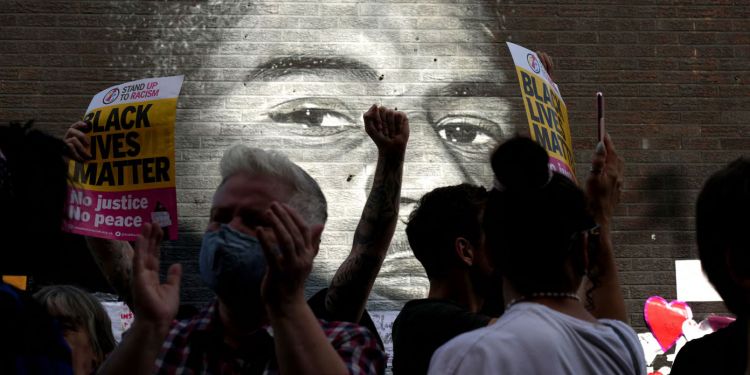 Black Lives Matter supporters gather in front of the newly repaired mural of England footballer Marcus Rashford © Christopher Furlong/ Getty Images