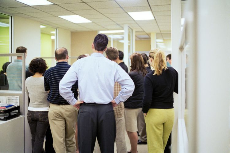 Office employees standing in a huddle at a doorway