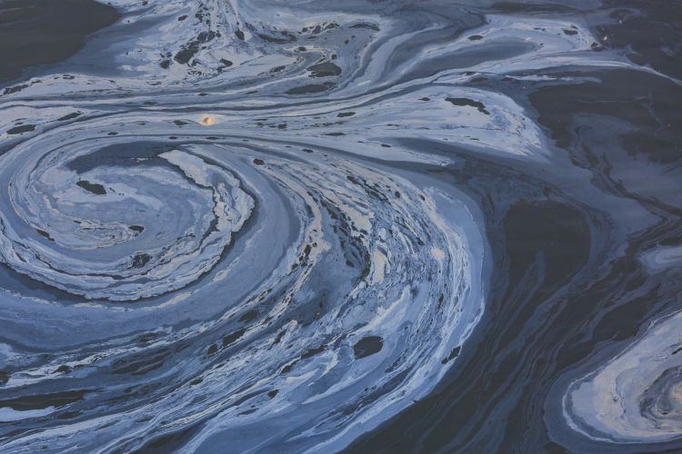 The view from above of a layer of oil, a slick on the waters