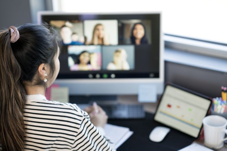 Woman Attending Virtual Meeting in Home Office Setting with Modern Equipment