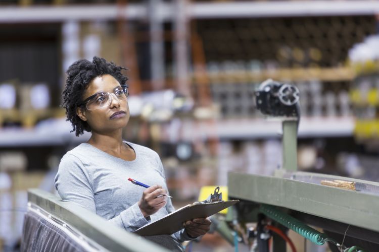 Mid adult, African American woman (30s) working in manufacturing facility