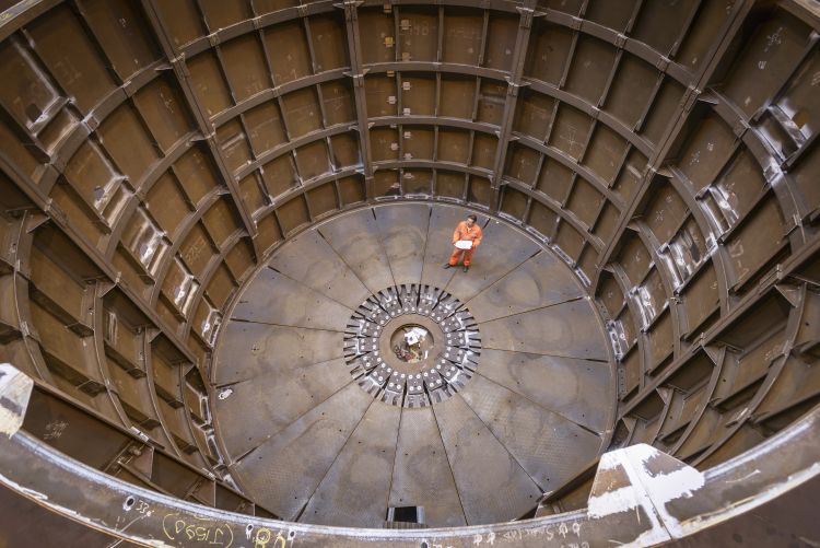 Engineer inspecting marine fabrication used for cable laying, high angle view