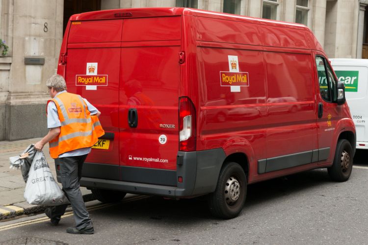 A man delivering mail in the financial district in Westminster late in the day.