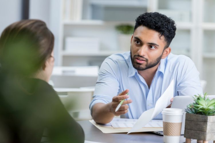 A man and a woman at a desk talking