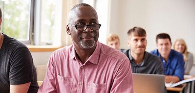 Mature Student Using Digital Tablet In Adult Education Class