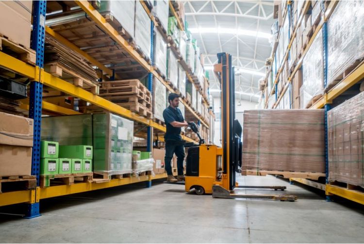 Man moving pallets in warehouse