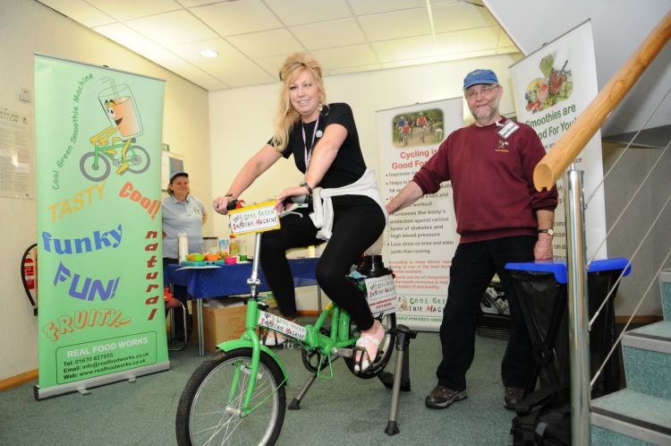 Woman riding a bike-powered smoothie machine