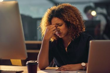 Women working at screen looking stressed 