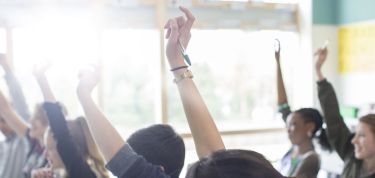 Raised hands in a classroom