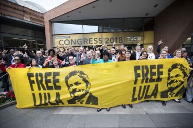 A group of delegates to the TUC Congress stand in front of a Free Lula banner