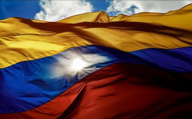The Colombian flag obscuring the sun that shines through the fabric