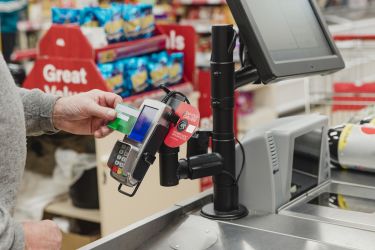 Man making a contactless payment at a supermarket till