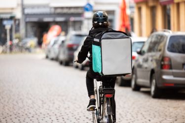 Delivery person with thermal box on a bicycle