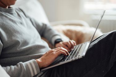 Cropped shot of young man typing on laptop
