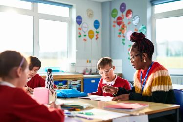 Primary school teacher helping boy with his school work