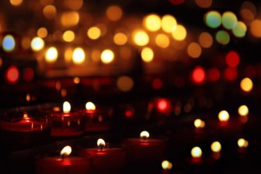 Many candles - candlelight in the darkness - stock photo