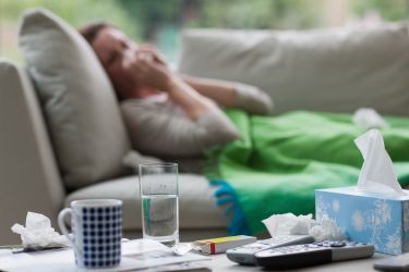sick woman laying on sofa