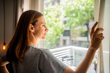 women looking through a window at home