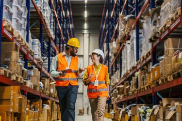 Warehouse workers checking inventory and discussing logistics 
