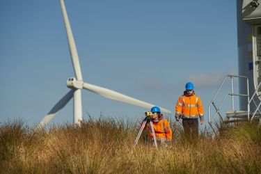 Workers installing wind turbines