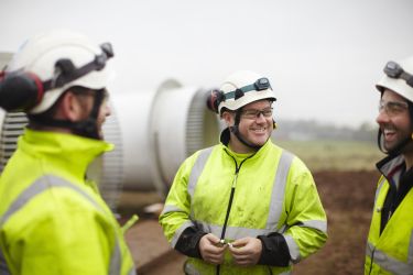 Engineers having conversation at wind farm - stock photo