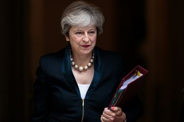 British Prime Minister Theresa May walking out of 10 Downing Street holding a folder