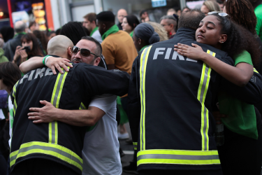 LONDON, ENGLAND - JUNE 14: People stop to hug firefighters during a silent march to St Marks Park (Kensington Memorial Park) 