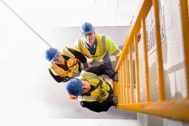 Apprentice builders learning how to climb ladders in training facility