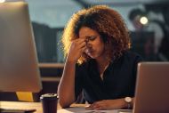 Woman working late and looking stressed 