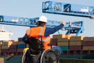 Port worker in wheelchair directing colleague