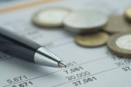 Ballpoint pen with written budget and pound coins