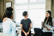 Four women standing up talking