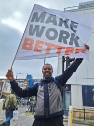 Outsourced worker holding 'make work better' flag