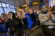 Three women applauding and laughing at an event
