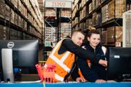 Tesco workers viewing computer at distribution centre