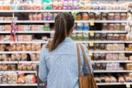 An unrecognisable woman looks at a supermarket shelf