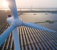 Wind turbine with solar panels in the background