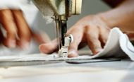 Close-up of Worker Sewing Clothing in Garment Factory