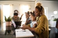 Family looking at phone and laptop